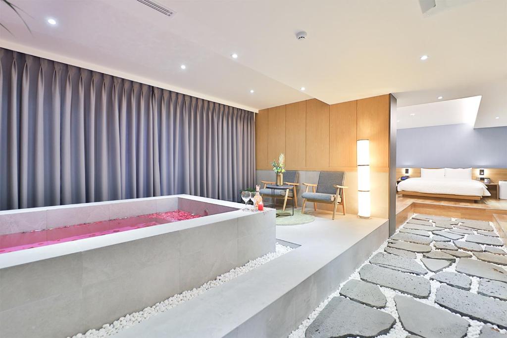 蔚山Custom Hotel的中间设有带大浴缸的客厅