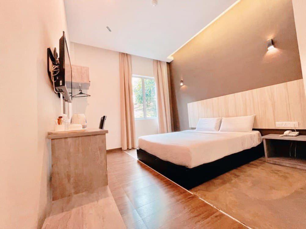 关丹KARANG TIMUR MOTEL的酒店客房,配有床和电视