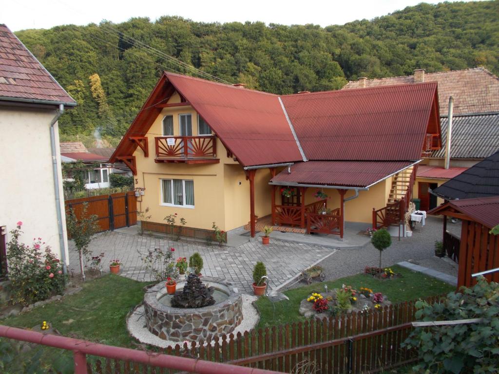 索瓦塔Napsugár Vendégház的一座红色屋顶和喷泉的房子