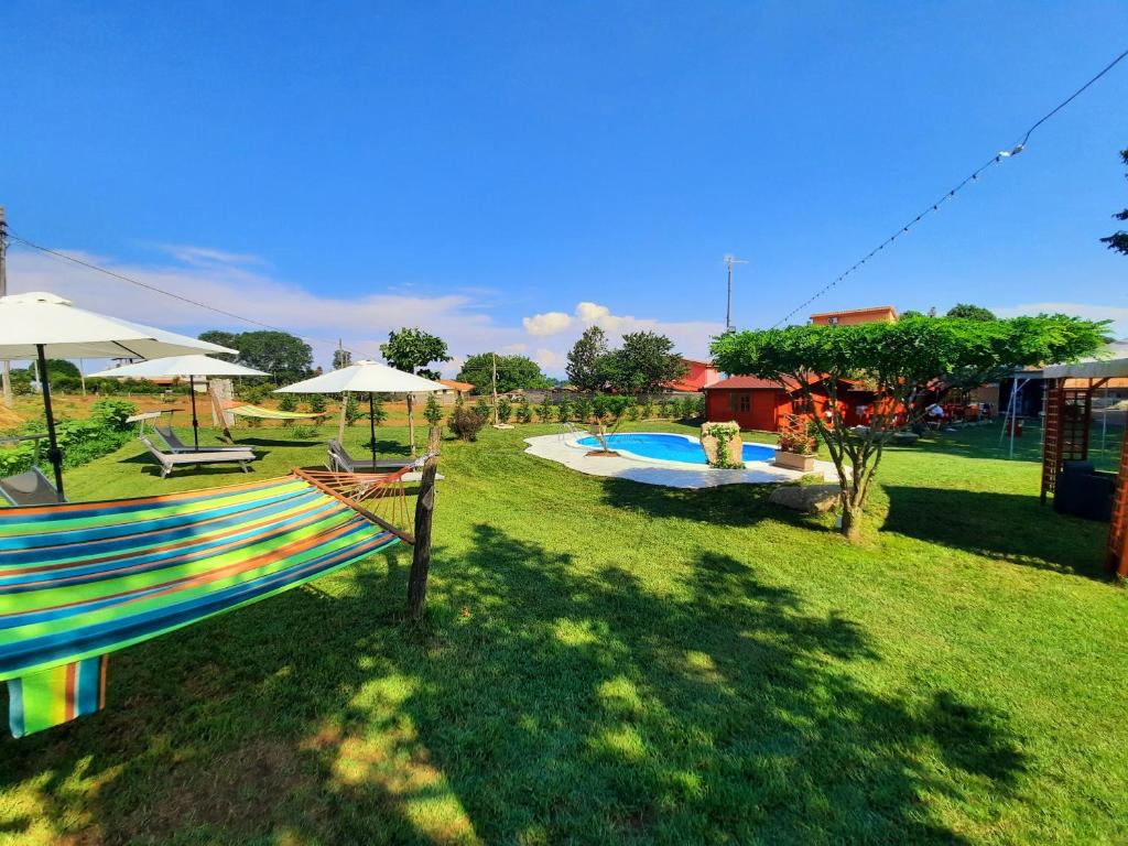 SpilingaResidence Il Tiglio的一个带遮阳伞和椅子的游泳池的庭院和一个庭院