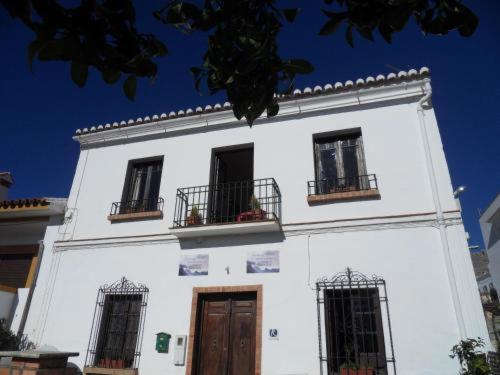 康塞普西翁新镇El Rincon del Torcal的白色的建筑,有三扇窗户和门