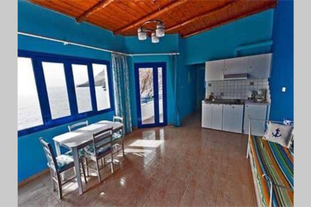 霍拉斯法基翁Great sea-view apartment.的厨房拥有蓝色的墙壁,配有桌椅