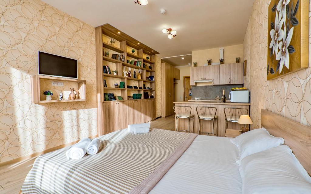 古多里Studio Apartment NFT New Gudauri 108的一间带大床的卧室和一间厨房