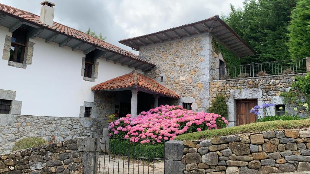 Quintana de SobaEl Jardin de las Magnolias Hotel的前面有粉红色花的房子