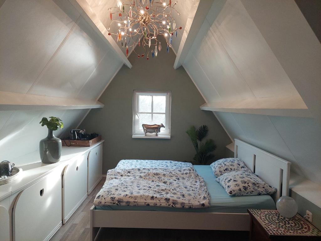 博文卡尔斯佩尔Chez Bob的一间卧室配有一张床和一个吊灯