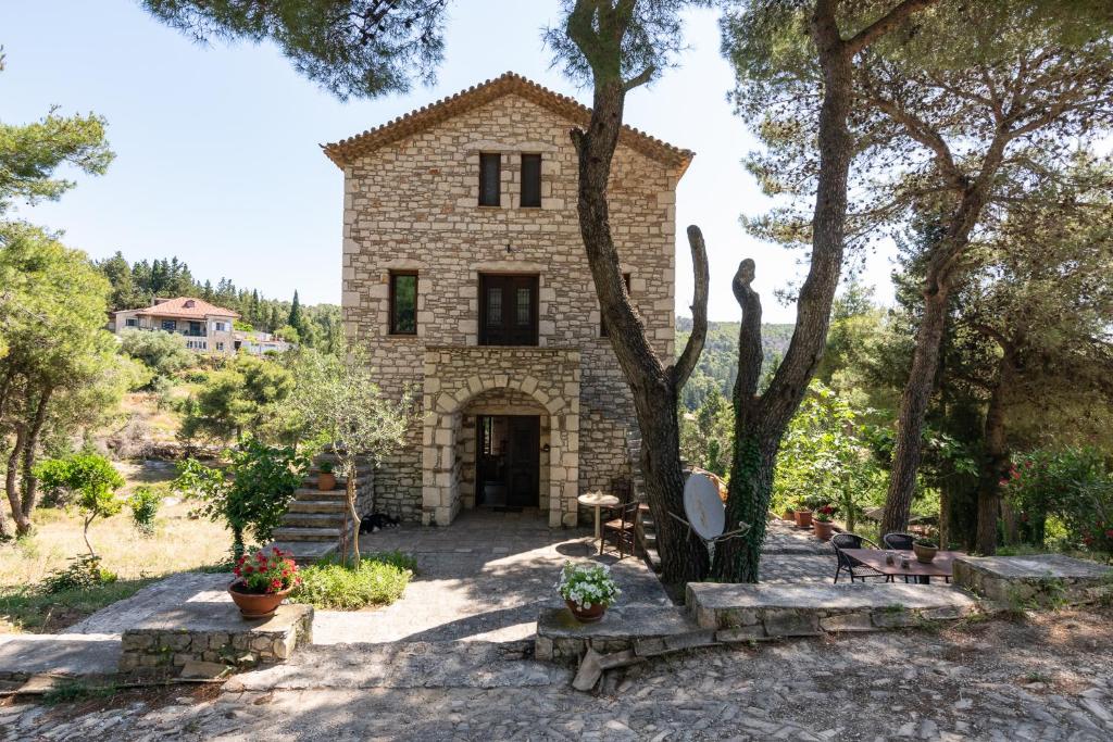 Ágios NikólaosVilla Castello的前面有棵树的石头房子