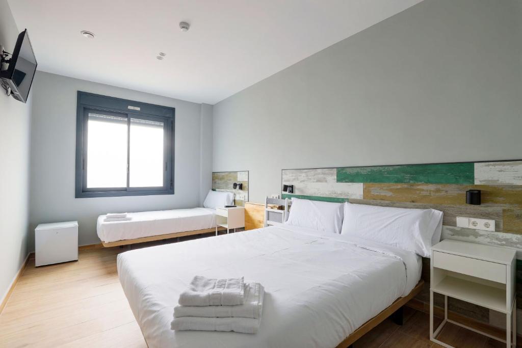 塞丹约拉·德尔·瓦勒Hey Rooms的卧室配有带毛巾的大型白色床