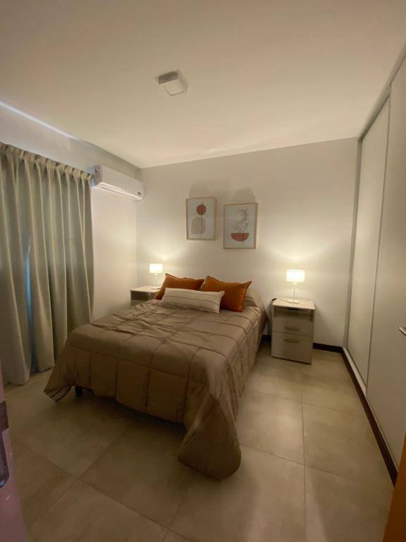 巴拉那Hermoso departamento céntrico con estacionamiento的一间卧室配有一张带两盏灯的床。
