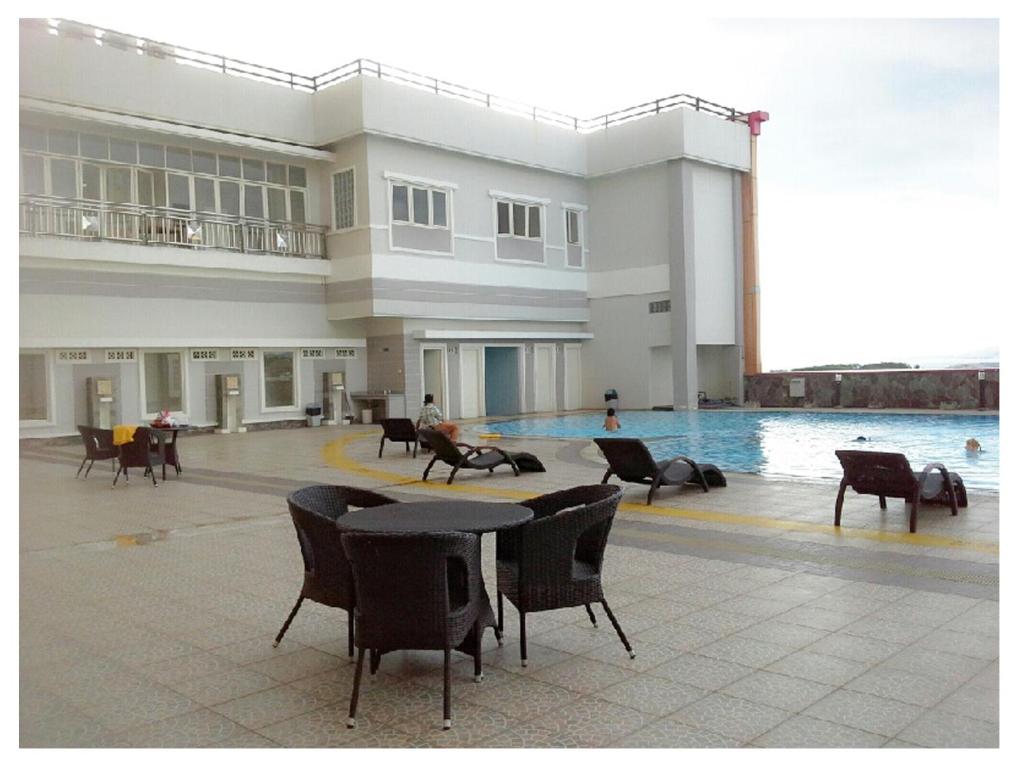 美娜多MTC公寓的一座带游泳池和桌椅的大型建筑