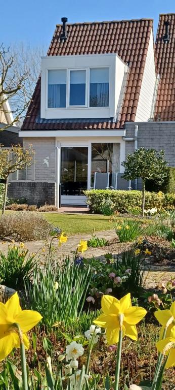 栋堡Garden cottage Domburg的前院内花黄色的房子