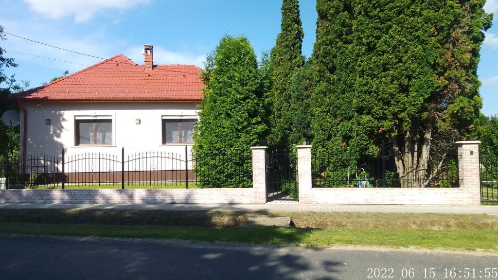 KerkakutasAlmafás Vendégház Őrség的白色的房子,有栅栏和树木