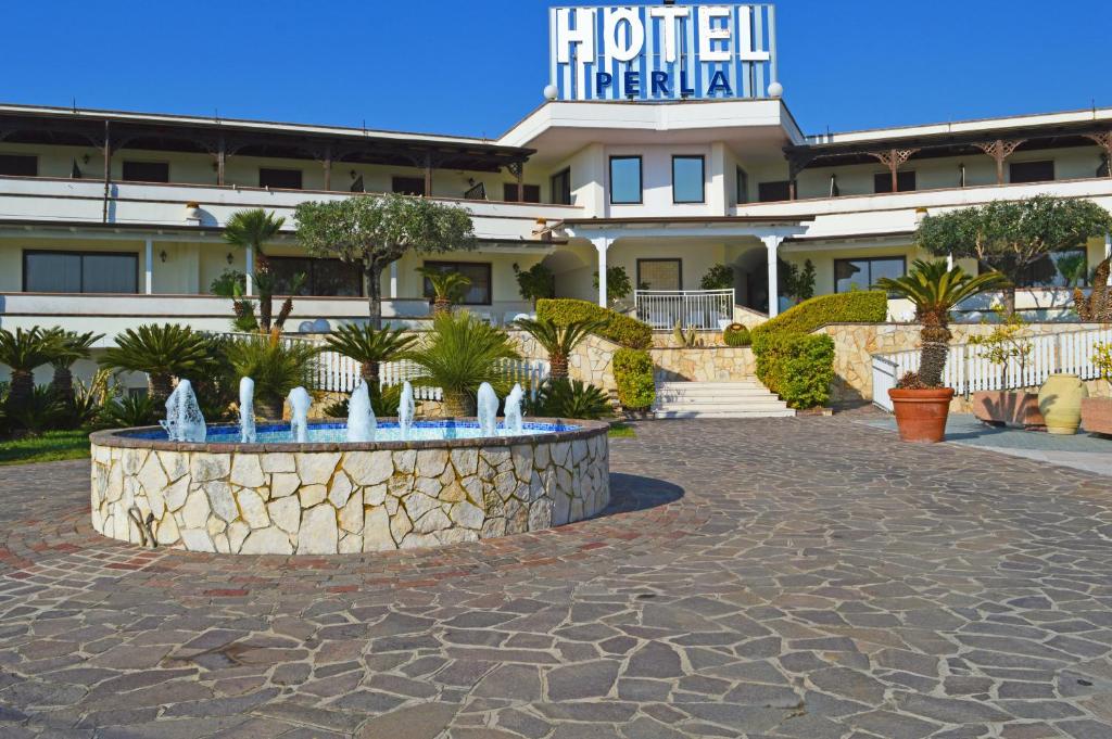 卡帕乔-帕埃斯图姆Hotel & Resort Perla的一座建筑前有喷泉的酒店