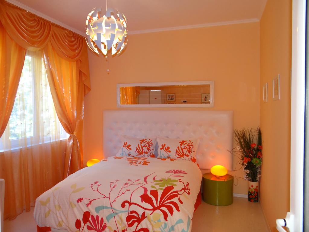 索非亚橙花1号公寓的一间卧室配有一张床和一个吊灯