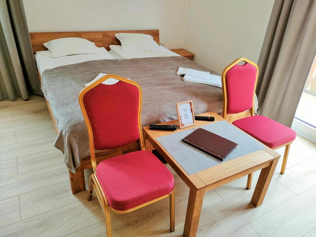 哈茨山区黑尔茨贝格AM BERG Hotel的卧室配有一张床和一张桌子及椅子
