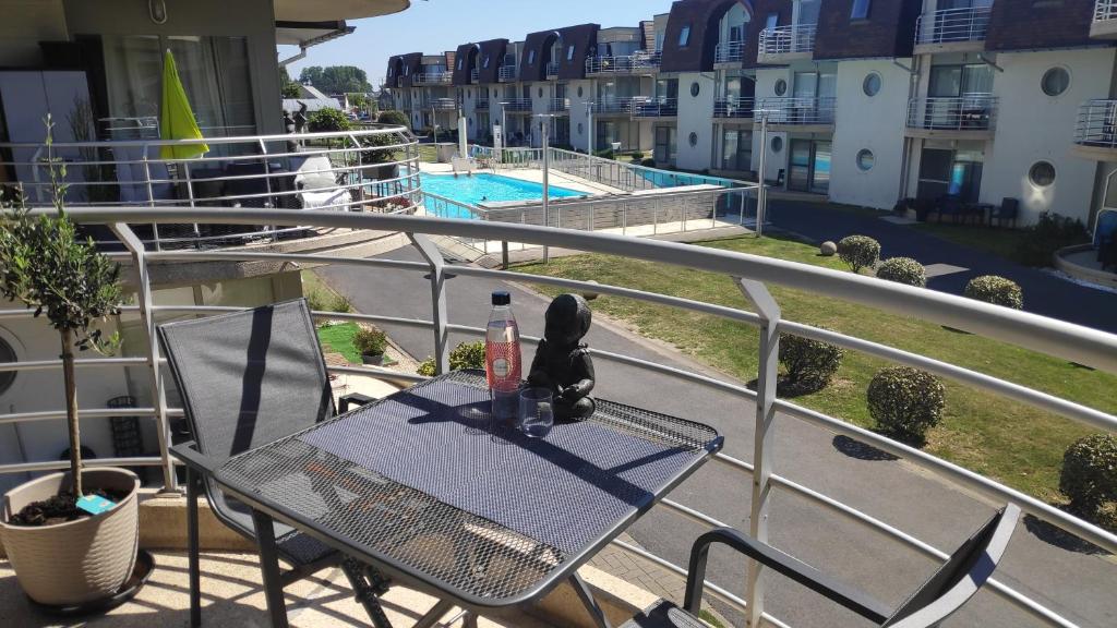 布列登Blutsyde Promenade Encanto的阳台配有桌椅,享有泳池美景