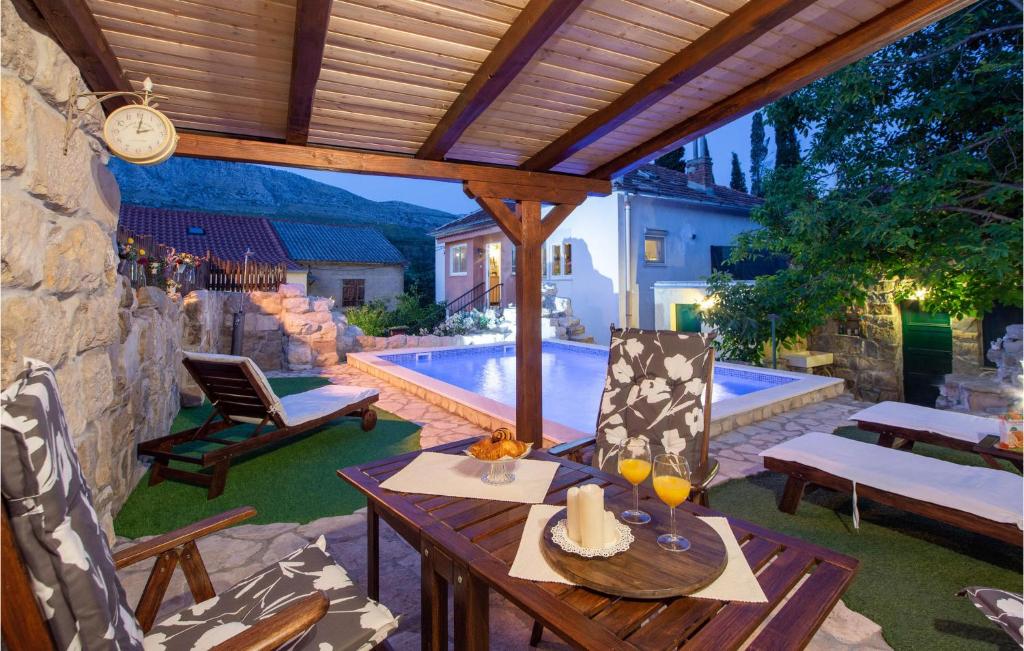 斯林Nice Home In Srinjine With Wifi的一个带桌椅的庭院和一个游泳池