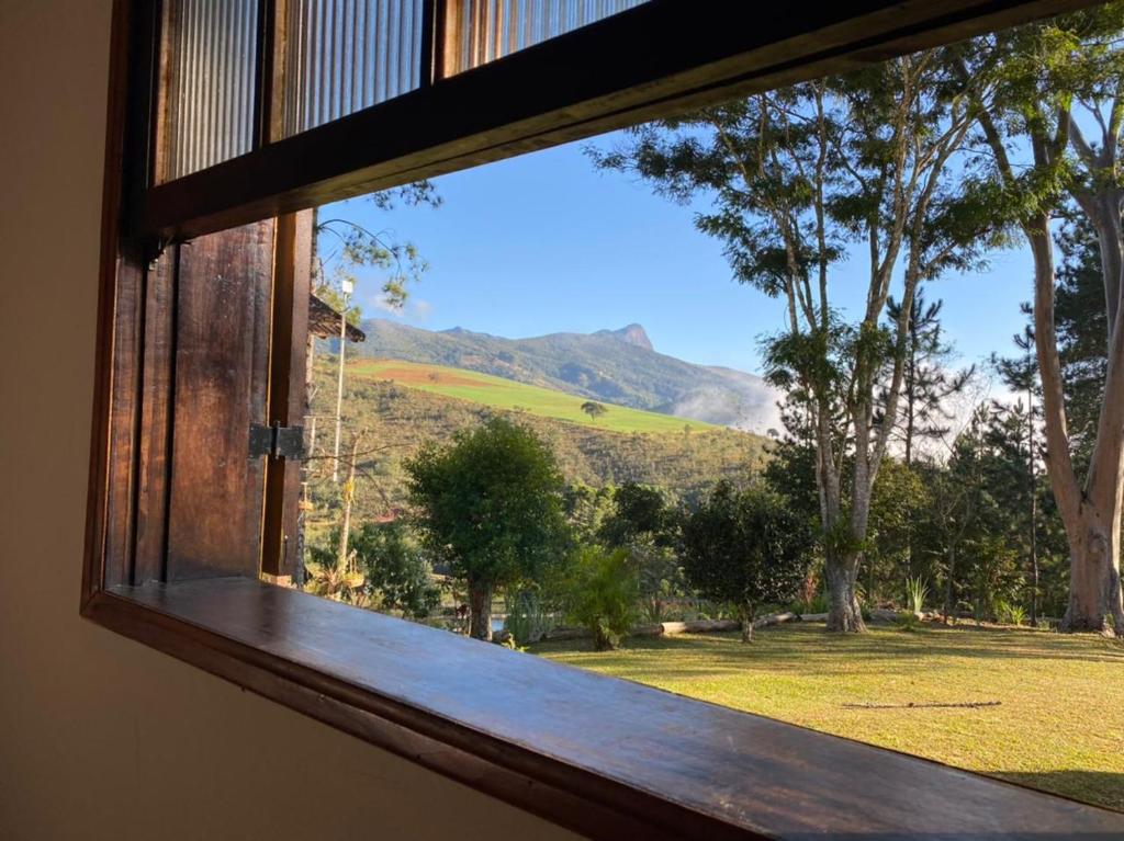 阿尤鲁奥卡Pousada Lenda da Montanha的享有田野和山脉景致的窗户。
