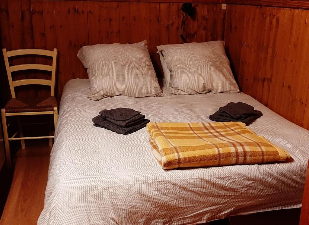 MeillerieChâlet vue lac Léman à 1000 mètres d altitude的床上有两张枕头,有毯子