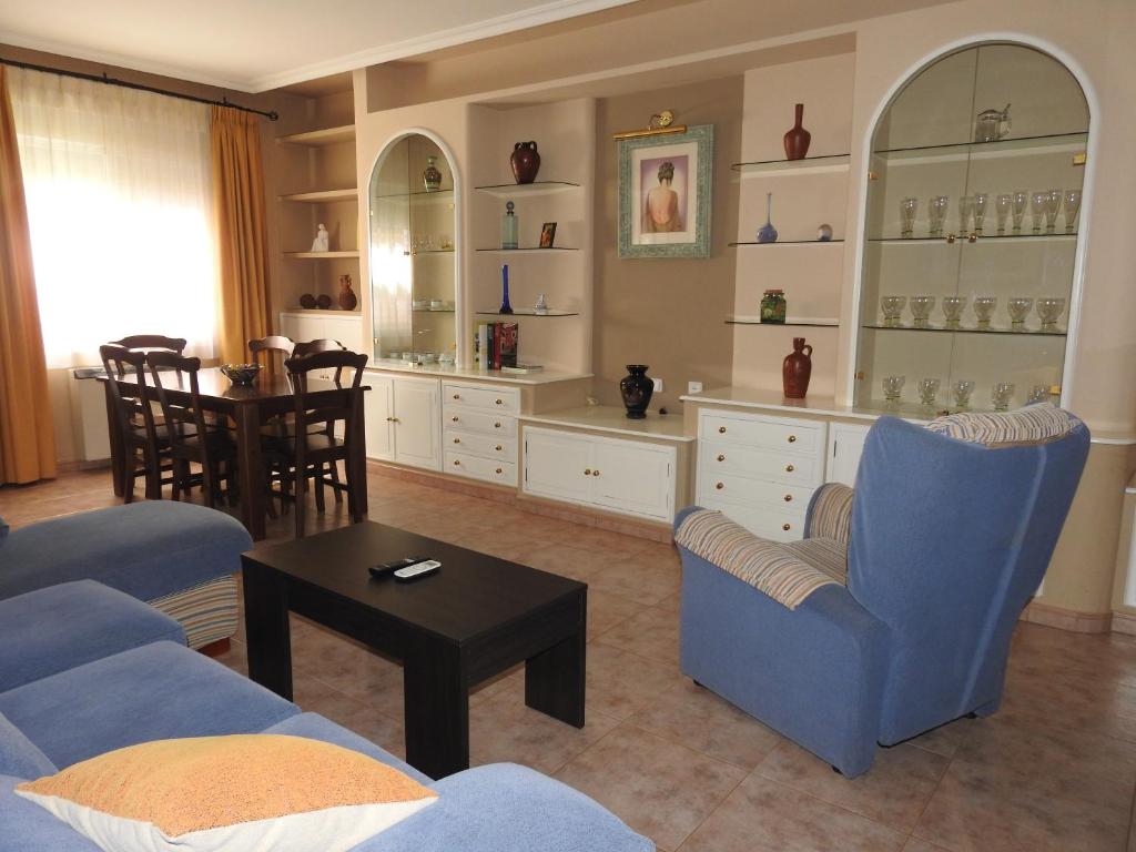 Bolaños de CalatravaLa Morada Casa Rural的客厅配有蓝色的椅子和桌子