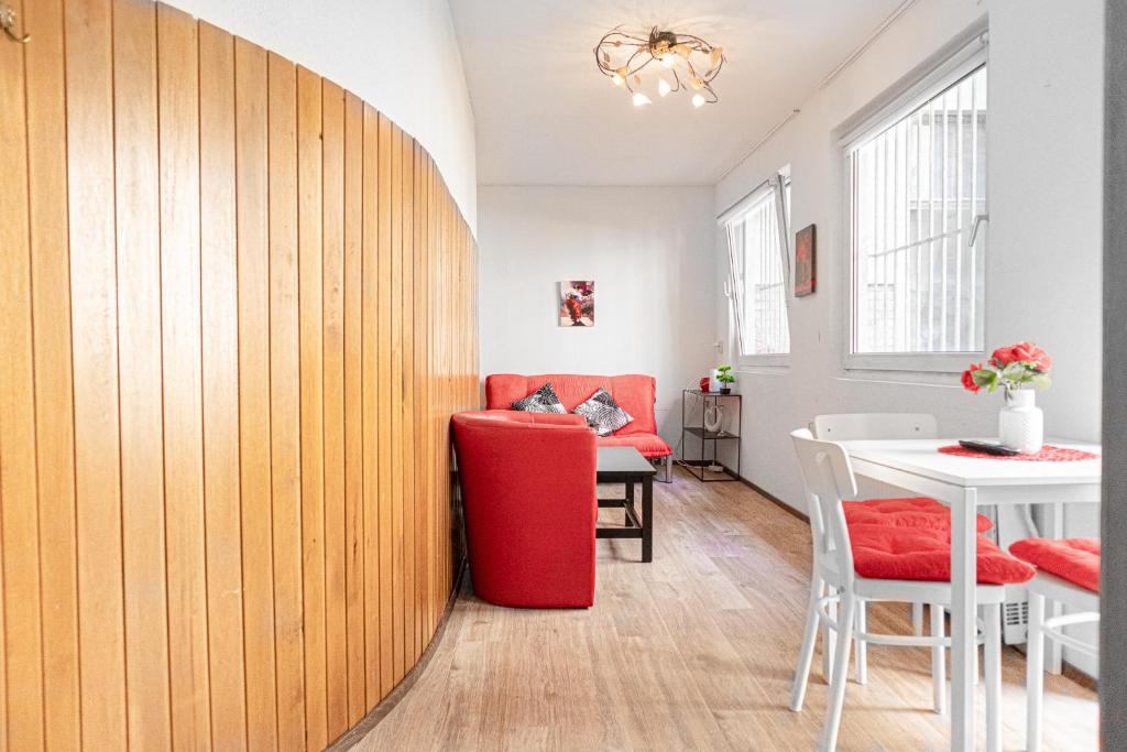 维也纳Timeless Red 1BR Apartment - Great for Longstays的客厅配有红色椅子和桌子