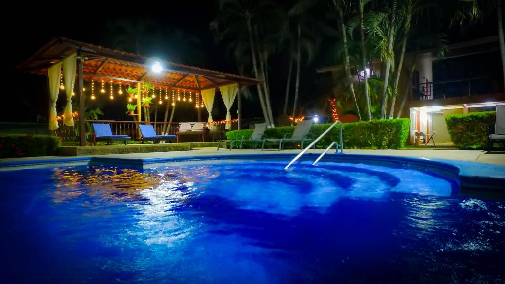 普拉亚埃尔莫萨胡特伦斯别墅酒店的夜间游泳池与房子