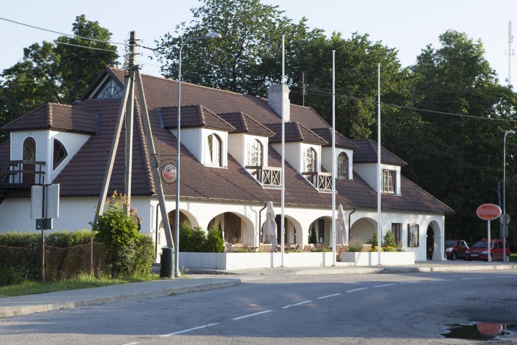 Käina里拉酒店的一间白色的大房子,有棕色的屋顶
