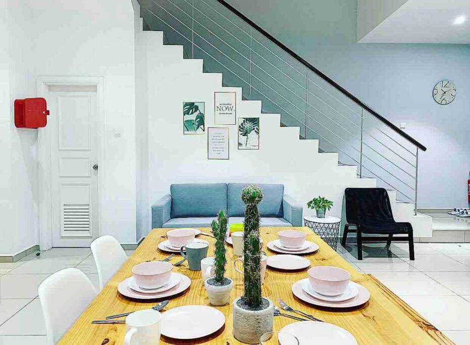 马六甲Fifteen Famiglia Malacca - Homestay的一间带桌子和楼梯的用餐室