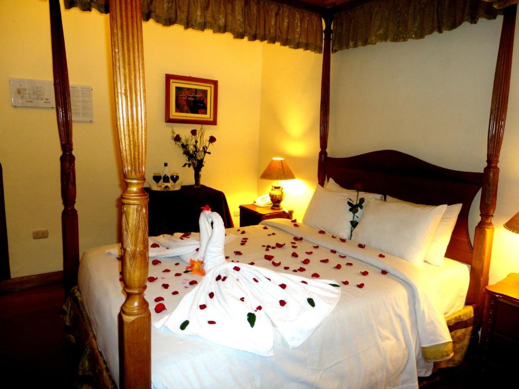库斯科绿色酒店的一间卧室配有一张红色的四柱床