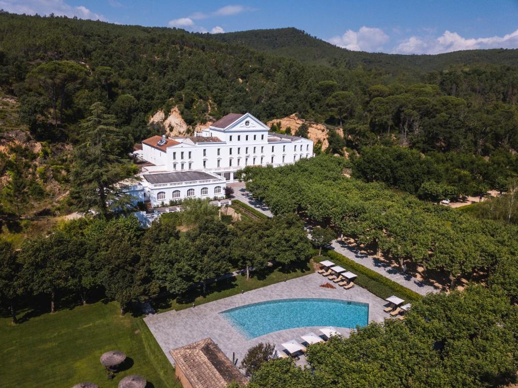 圣科洛马·德法尔巴尔尼亚里奥瑞翁温泉酒店的享有带游泳池的大型白色建筑的空中景致