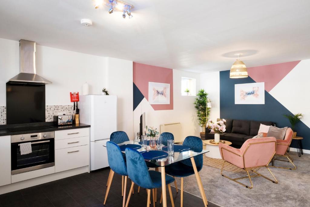 赛伦塞斯特Corinium Lodge - town centre apartment的厨房以及带桌椅的起居室。