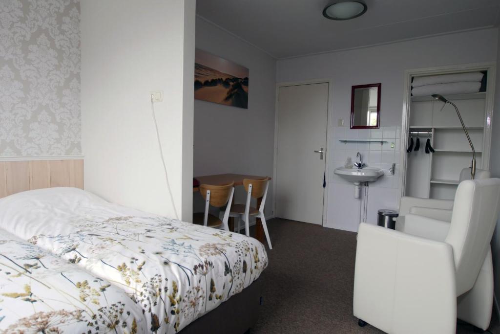 登霍伦Texelstrand的一间卧室配有一张床、一把椅子和一张桌子