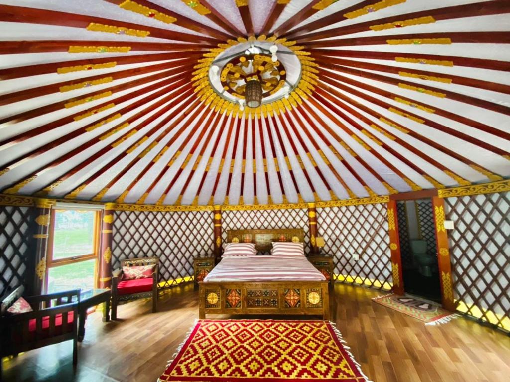 KalāmThe Glamping Spot Kalam的一间设有床铺和红色及白色天花板的客房