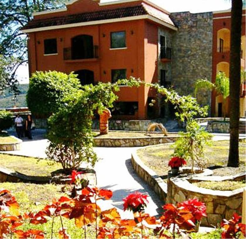圣地亚哥哈西恩达科拉德尔加巴洛酒店的一座建筑,前方有鲜花花园