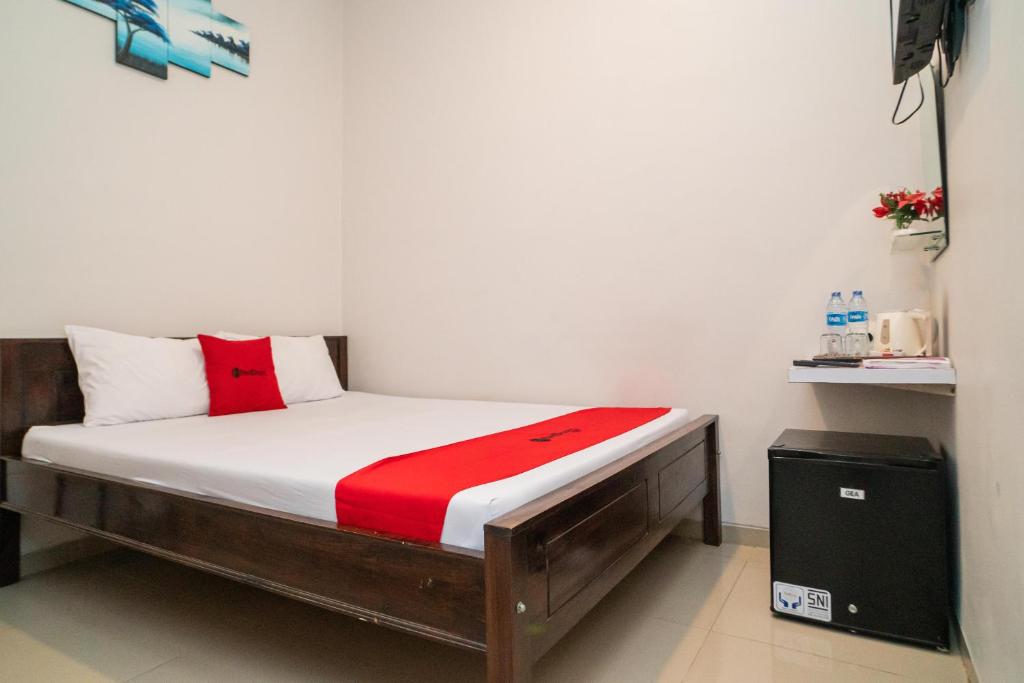 GununganjarRedDoorz Plus At Merr Rungkut Jl Gunung Anyar的一张位于一个红色和白色床垫的房间的床铺