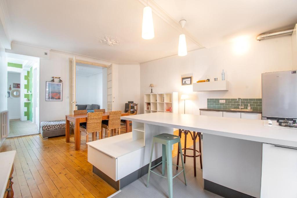 南特Superbe Appartement Calme 85m², à deux pas du Centre的厨房以及带桌椅的用餐室。