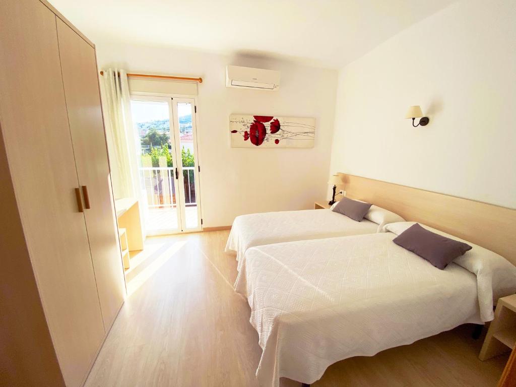 佩尼斯科拉Habitaciones Camping Ferrer的酒店客房设有两张床和窗户。