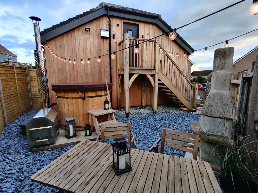 DraycottScandi-luxe Studio, with wood fired hot tub的一座带甲板和烧烤架的小木房子