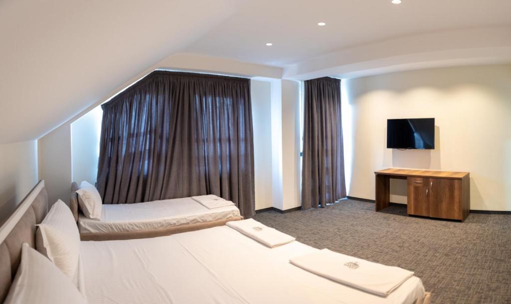 斯特鲁加Hotel Roma的酒店客房设有两张床和电视。