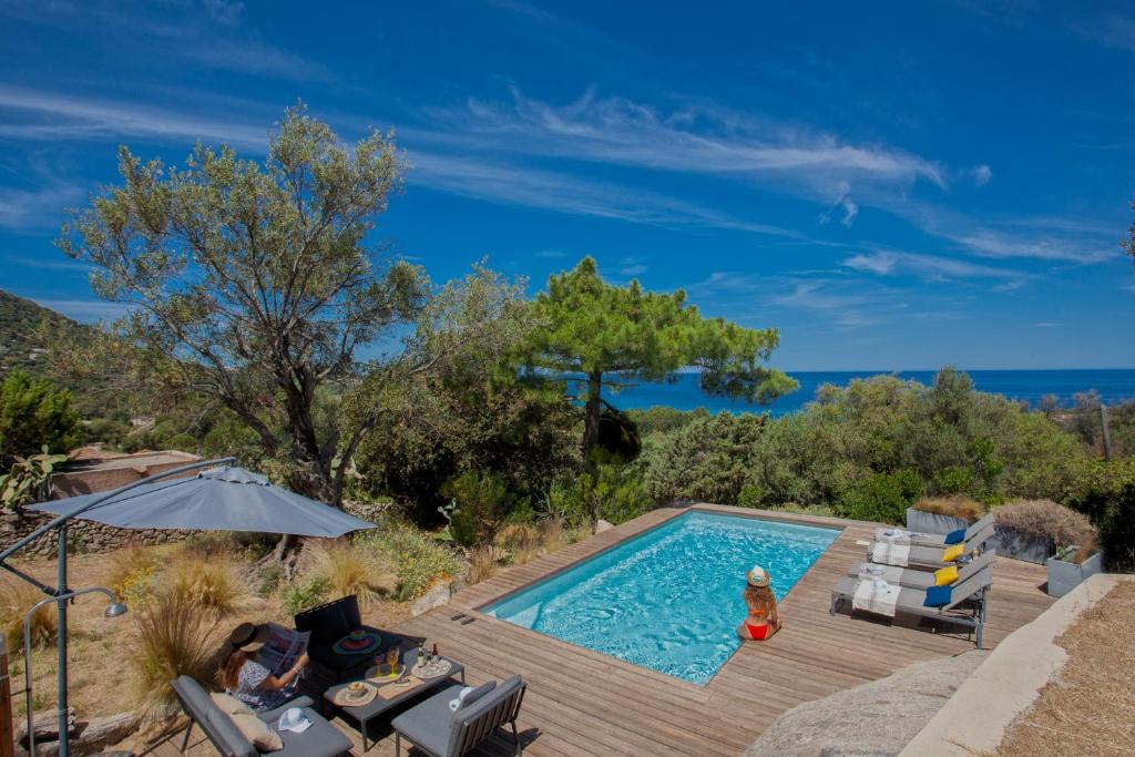利勒鲁斯Villa bodri, maison en pierre avec vue mer et piscine chauffée的海景木制甲板上的游泳池