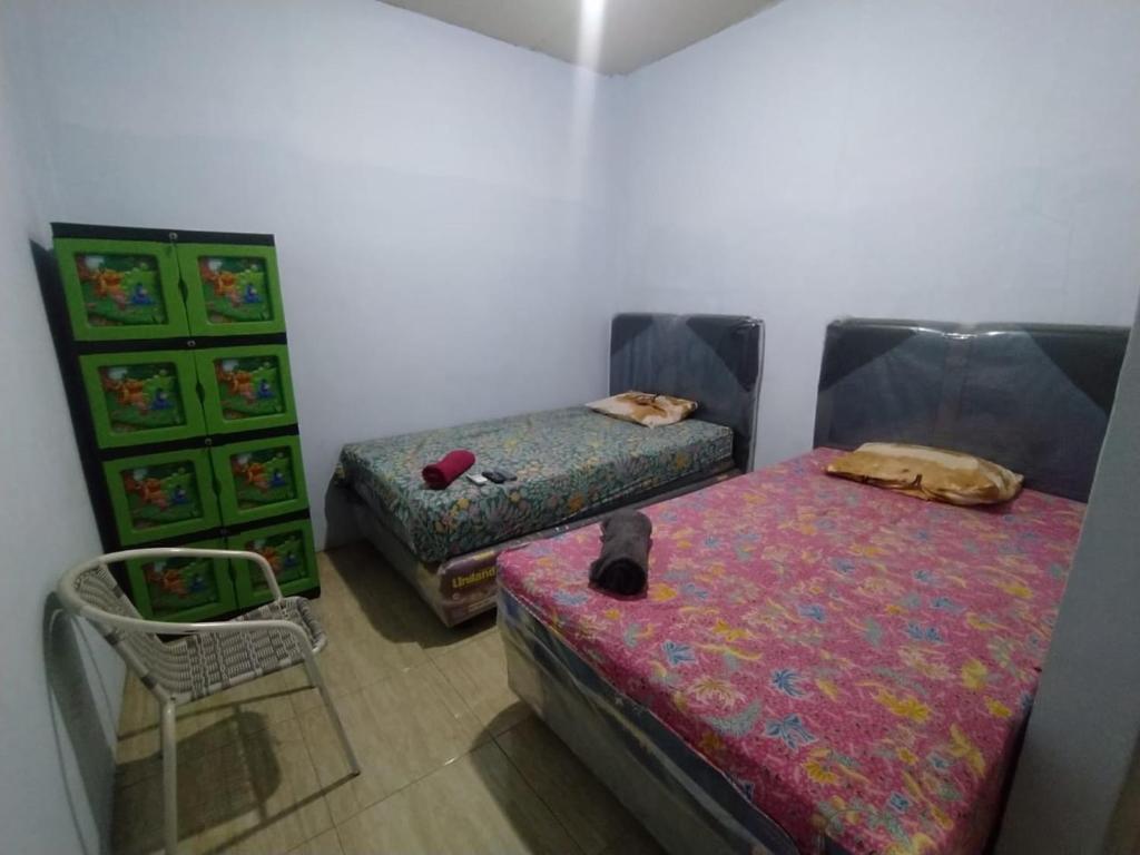 北加浪岸Hotel Near Ramayana 3的一间设有两张床和椅子的房间