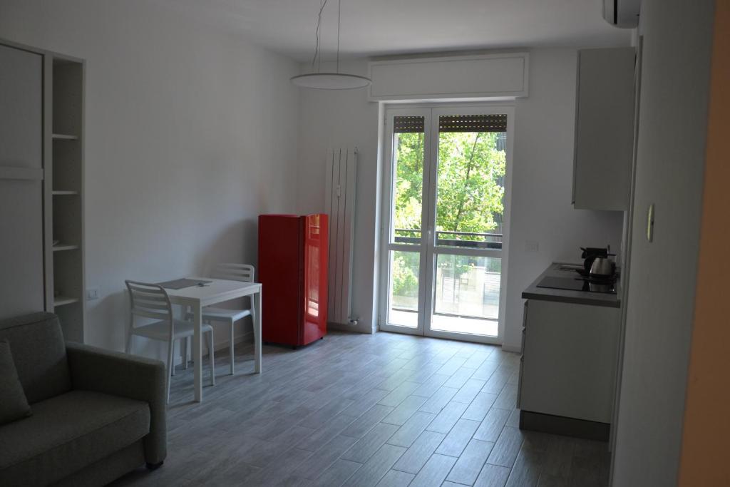 米兰Milano Fiera City - Apartments的客厅配有桌子和红色冰箱