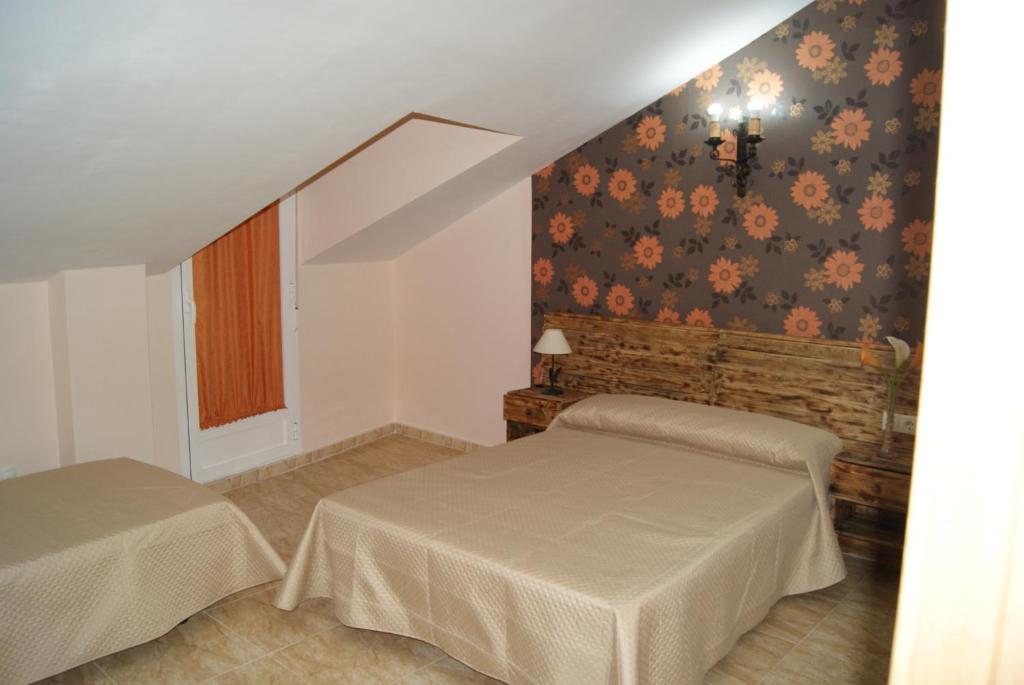 鲁伊德拉La casita rural de Sofia.的一间卧室设有两张床和鲜花墙