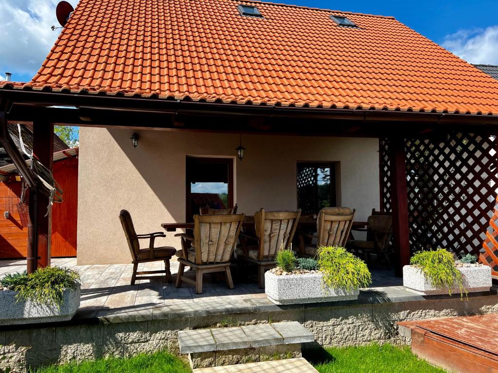 SněžnéChalupa Kadov的庭院设有椅子和桌子,拥有橙色的屋顶