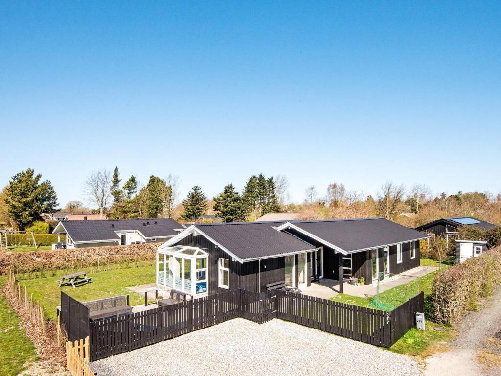 森讷比9 person holiday home in Juelsminde的前面有黑色围栏的房子