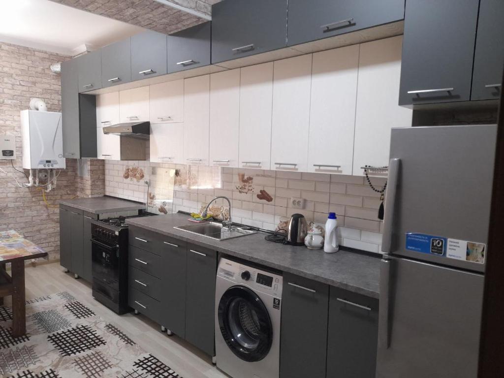 布哈拉Уютная 2-х комнатная квартира 82м2 в Центре города!的厨房配有洗衣机和冰箱。