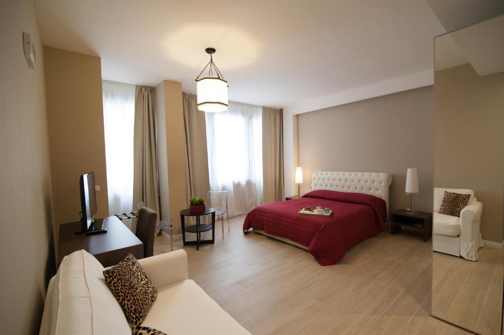 巴里Les Suites Luxury Bari Certified Italian Excellence的一间卧室配有一张床、一张沙发和一台电视。