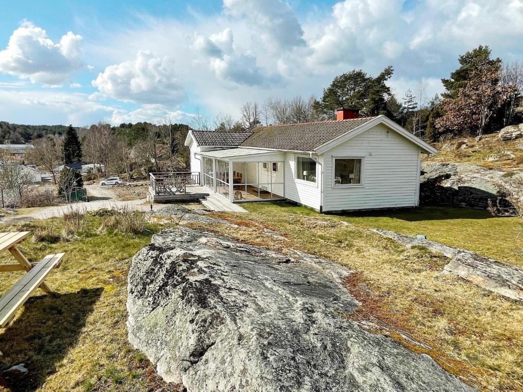 HjältebyHoliday home Hjälteby IV的一座白色的山丘房屋,有大岩石