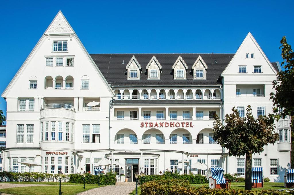 格吕克斯堡格吕克斯堡斯滕德酒店的一座白色的大建筑,上面有标志
