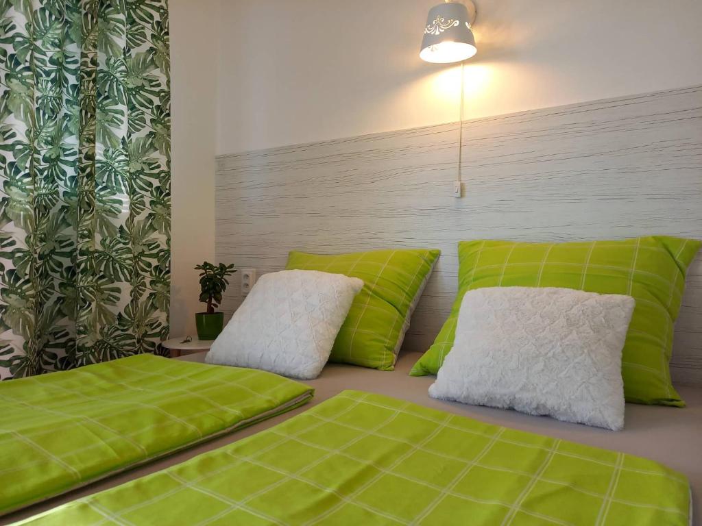 什图罗沃Afrodita的卧室配有带绿色和白色枕头的床。
