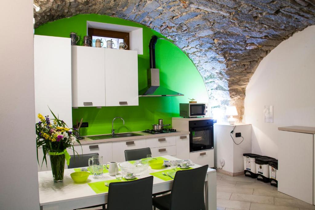 FiavèAppartamento Monte Misone的厨房配有桌子和绿色的墙壁